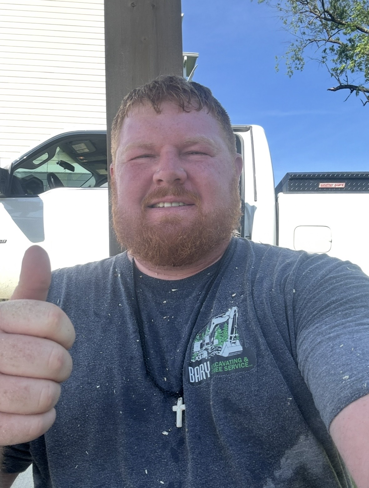 Bary, owner of Bary Excavating and Tree Service, giving a thumbs up in front of his work truck